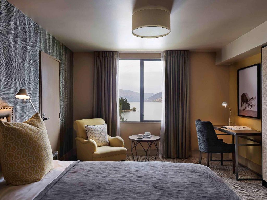 
a living room filled with furniture and a window at Hotel St Moritz Queenstown - MGallery by Sofitel in Queenstown
