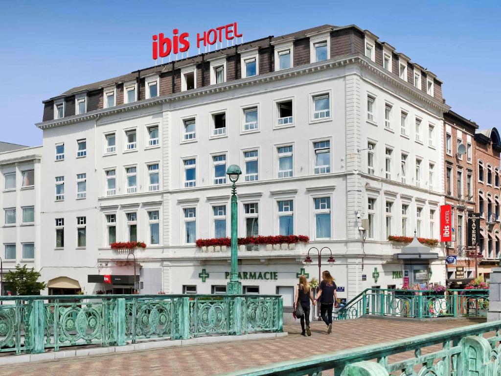 zwei Personen, die auf einer Brücke vor einem Gebäude spazieren in der Unterkunft ibis Charleroi Centre Gare in Charleroi