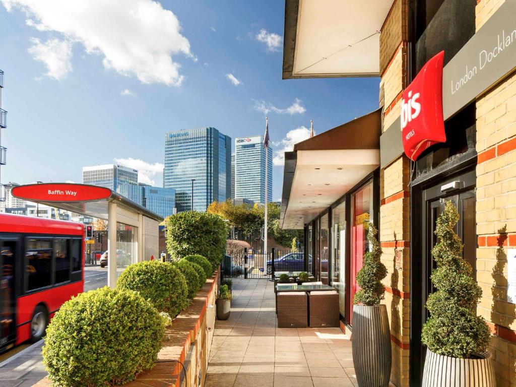 a sidewalk outside of a store with a bus at ibis London Docklands Canary Wharf in London