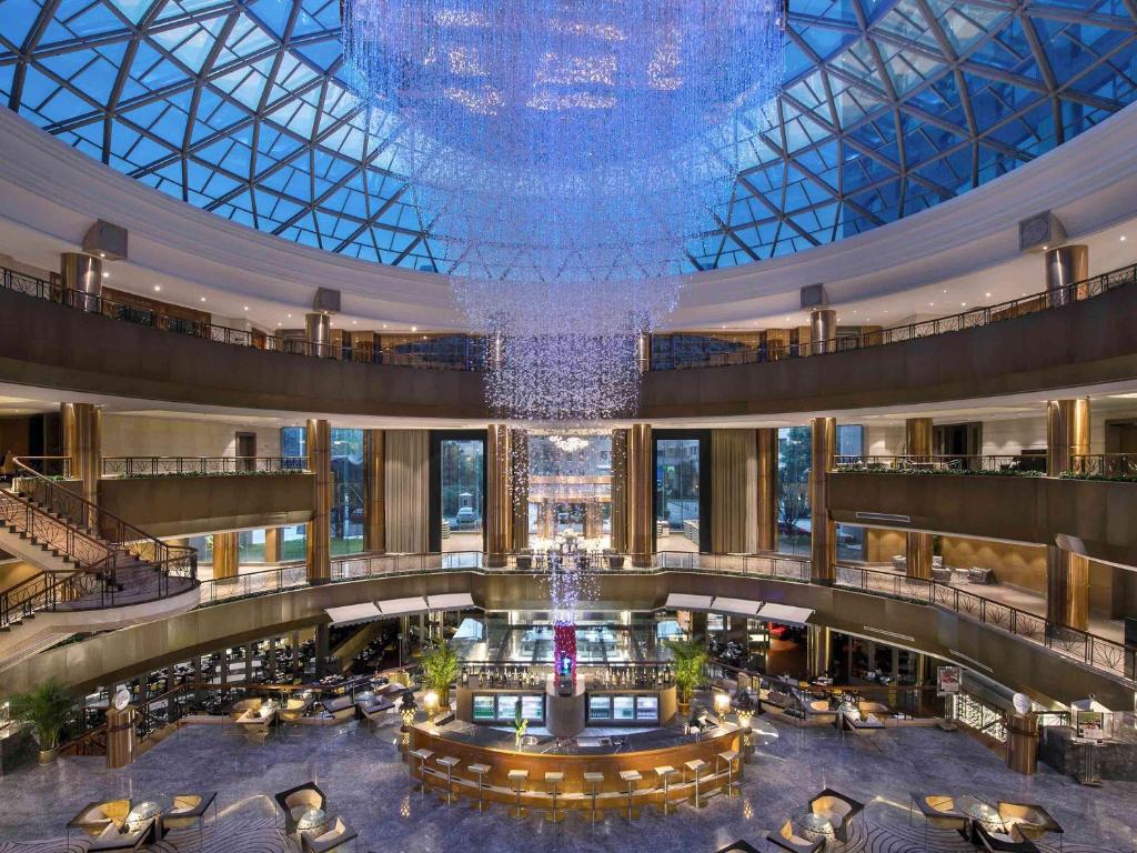 un grand hall avec un grand lustre dans un bâtiment dans l'établissement Sofitel Zhengzhou International, à Zhengzhou