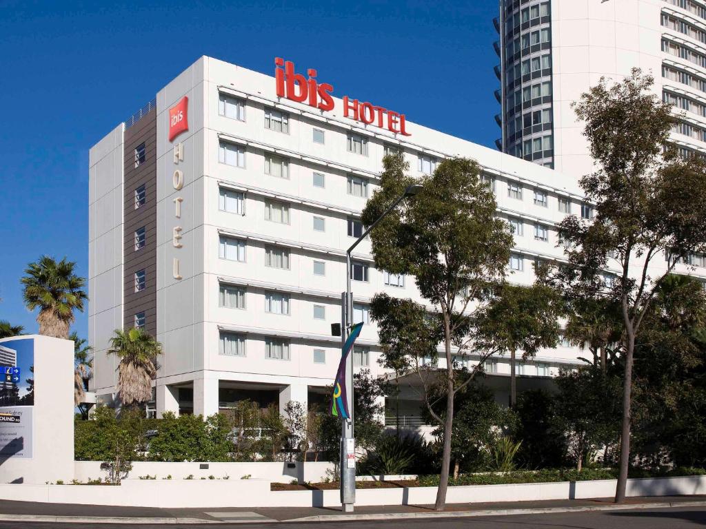 a big white building with a big sign on it at ibis Sydney Olympic Park in Sydney