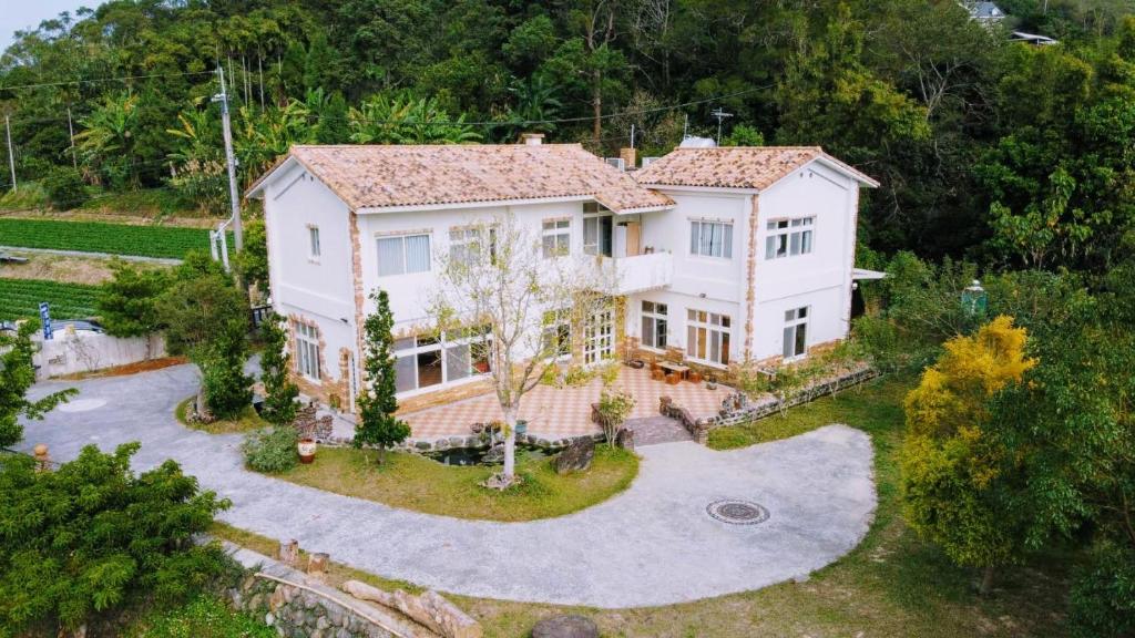 an aerial view of a large white house at The house behind stream in Dahu