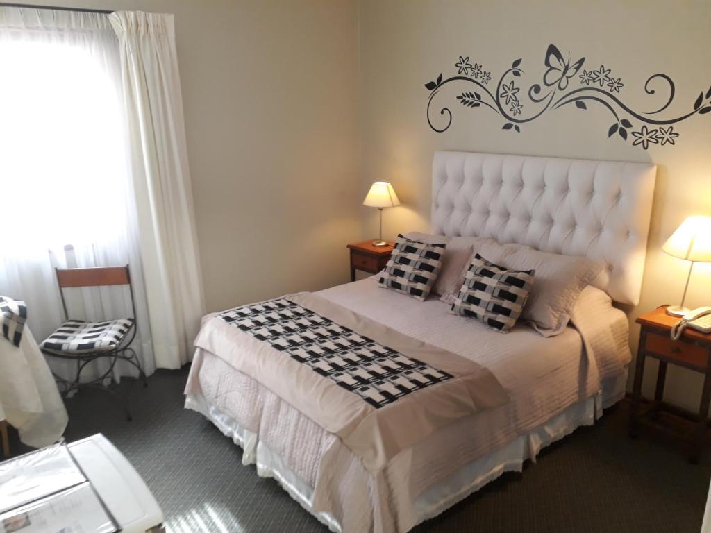 een slaapkamer met een bed met een zwart-wit dekbed bij Hotel Boutique 3 Poniente in Viña del Mar