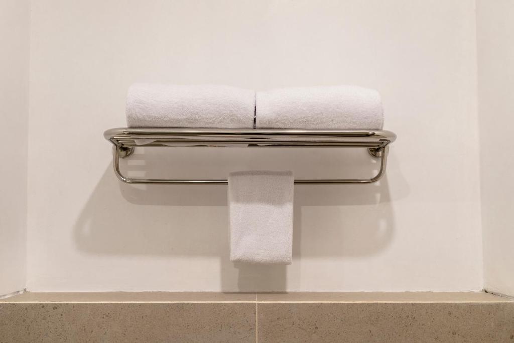 a towel dispenser with two towels in a bathroom at Cordia Hotel Yogyakarta - Hotel Dalam Bandara in Glagah