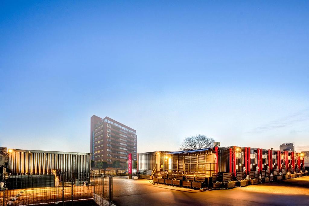 足利市にあるHOTEL R9 The Yard 足利駅西の建物前に列車が停車