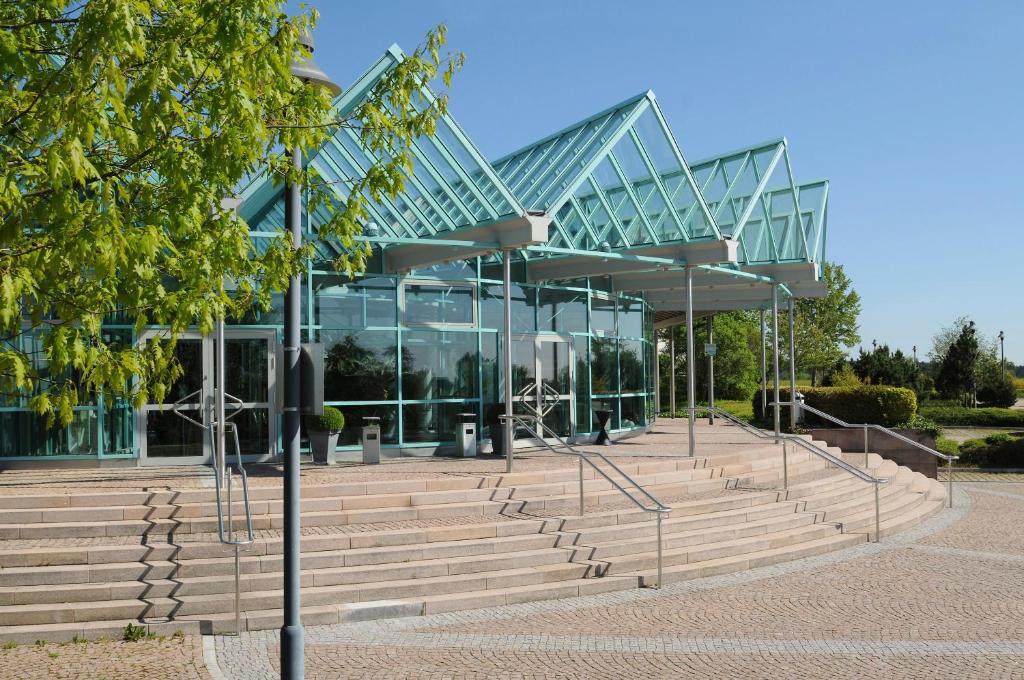 a glass building with stairs in front of it at DEKRA Congresshotel Wart in Altensteig