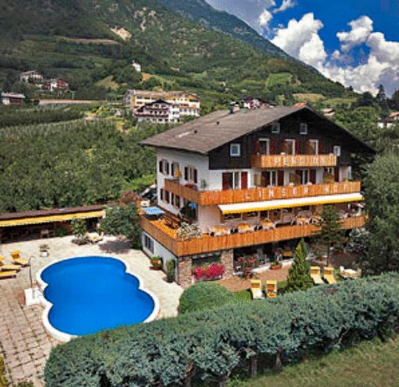 a large house with a large blue pool in front of it at Pension Linserhof in Naturno