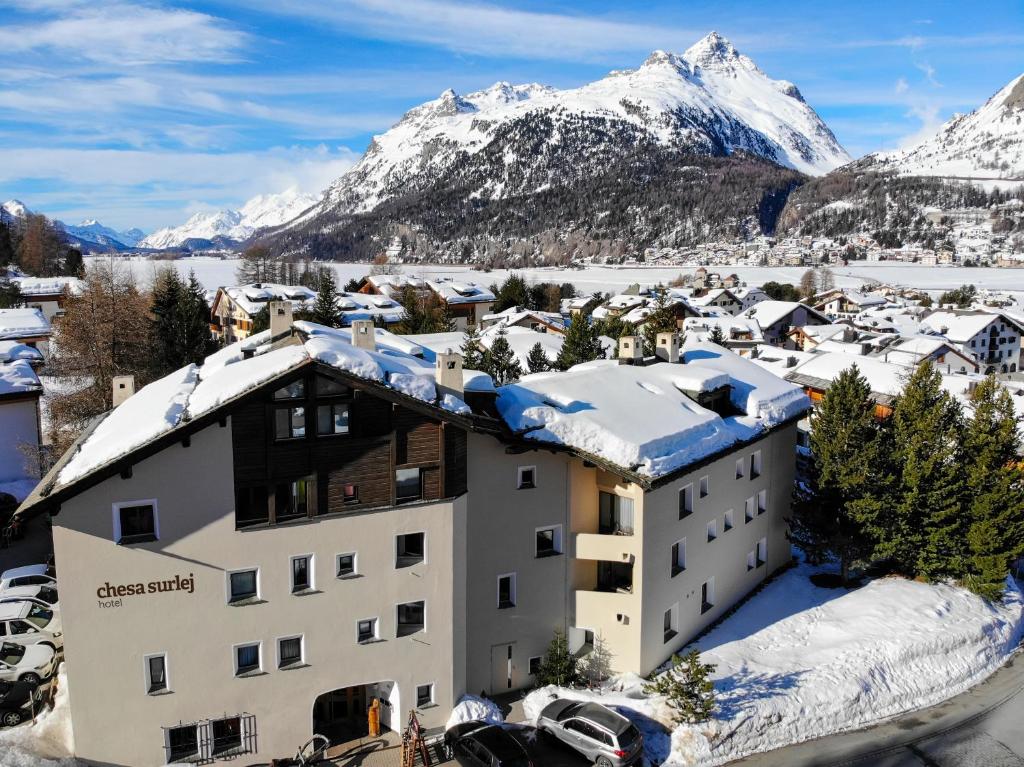 a hotel with snow covered mountains in the background at Hotel Chesa Surlej in Silvaplana