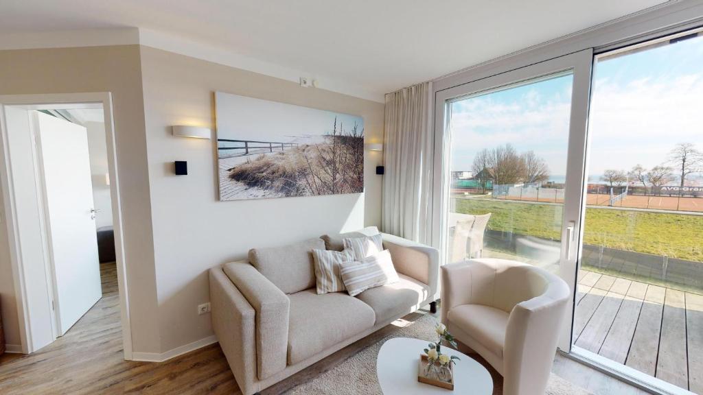 uma sala de estar com um sofá e duas cadeiras em Beach'n'Sea Wohnung 6 em Grömitz