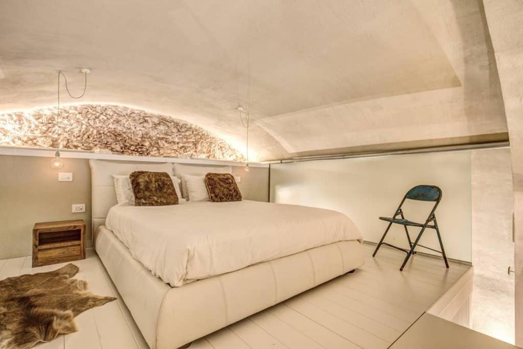 um quarto com uma cama grande e uma cadeira em LOFT DI DESIGN ESCLUSIVO em Rocca di Mezzo