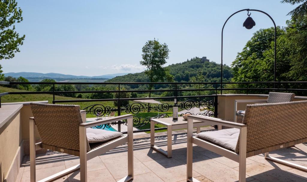 patio ze stołem i krzesłami na balkonie w obiekcie Relais Il Furioso w mieście Monte Castello di Vibio