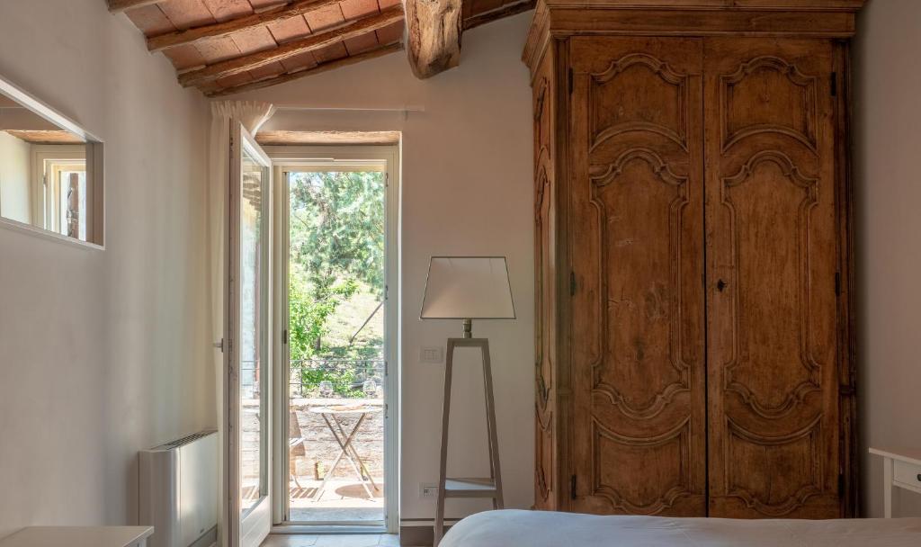 sypialnia z dużą drewnianą szafą i łóżkiem w obiekcie Relais Il Furioso w mieście Monte Castello di Vibio