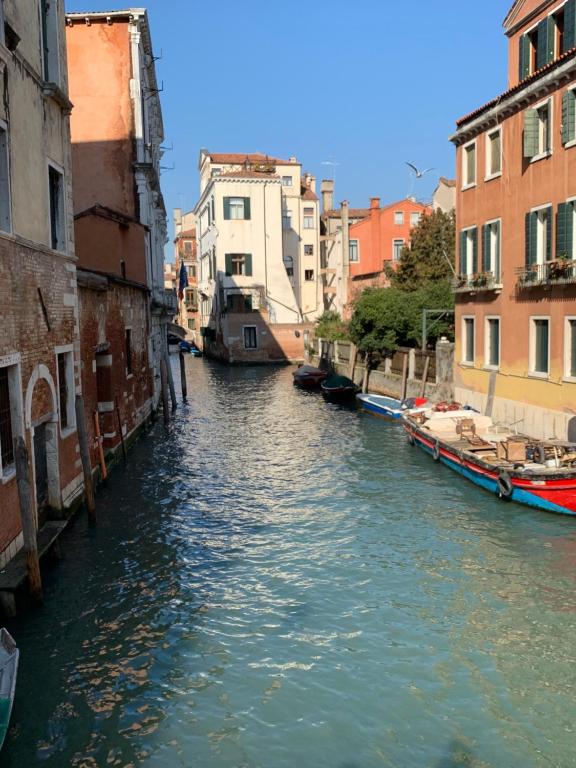 un canal en una ciudad con barcos en el agua en Home Lovers Apartment, en Venecia