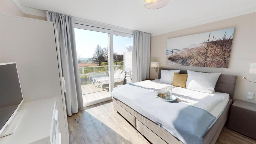 um quarto com uma cama grande e uma janela grande em Beach'n'Sea Wohnung 7 em Grömitz