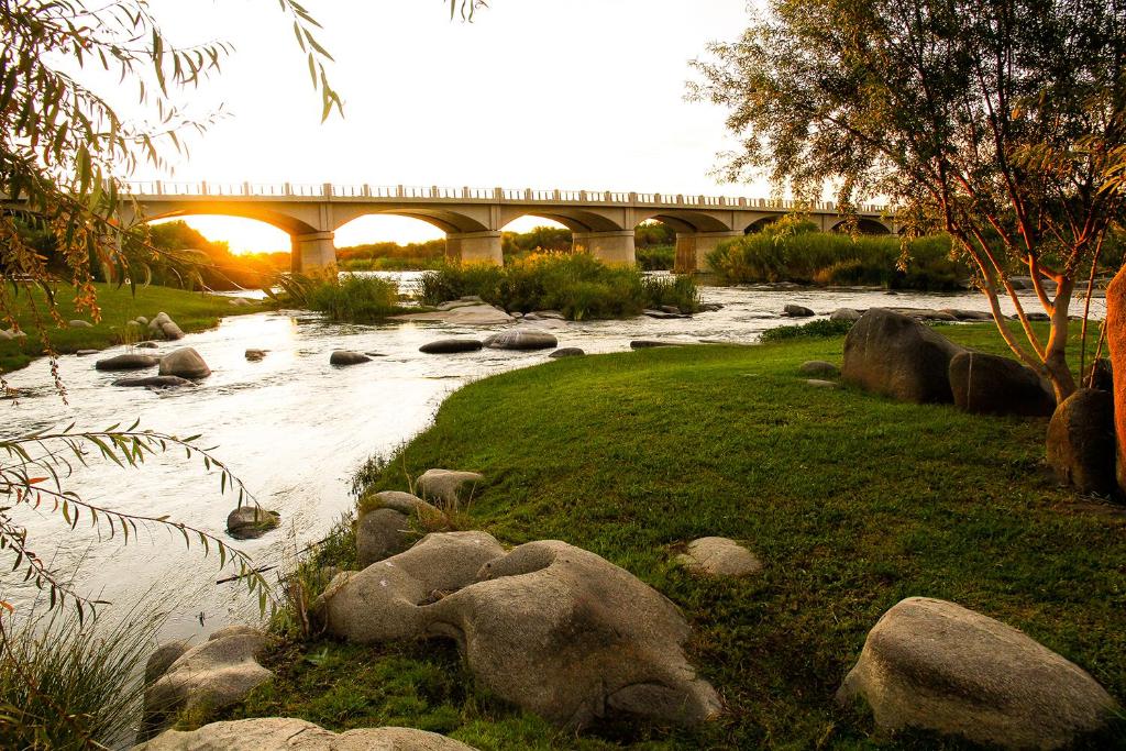 rzeka z kamieniami i most w tle w obiekcie Ikaia River Lodge w mieście Keimoes
