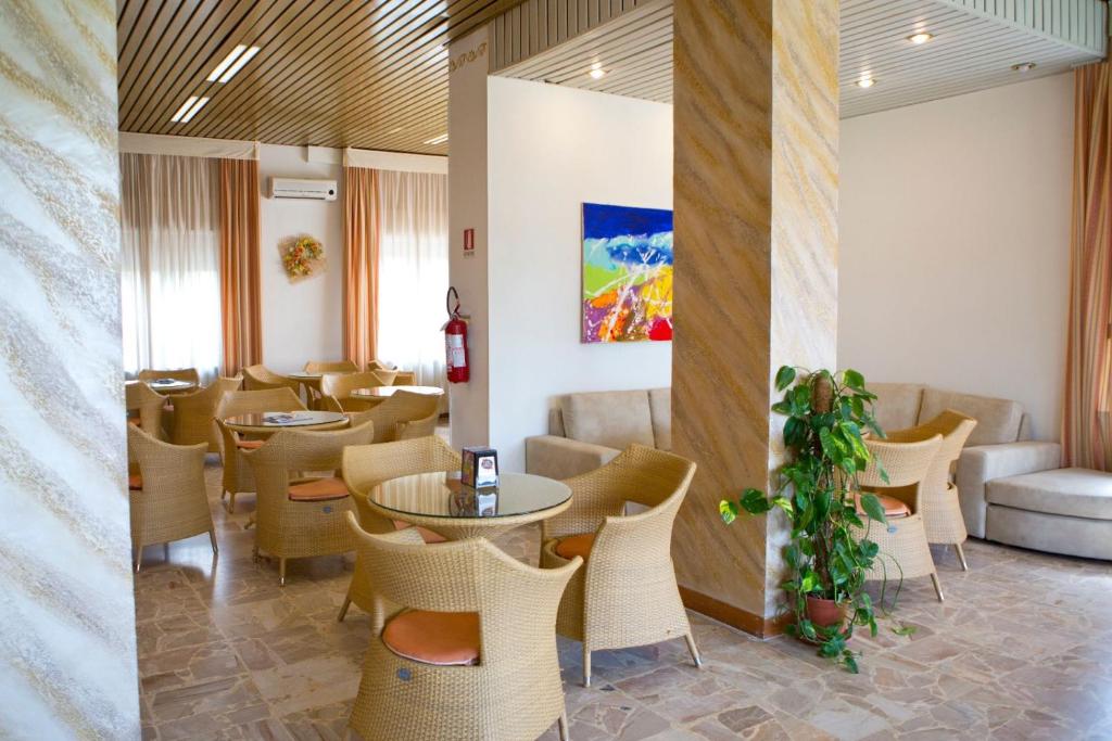 um restaurante com mesas e cadeiras num quarto em Hotel Kristall em Diano Marina