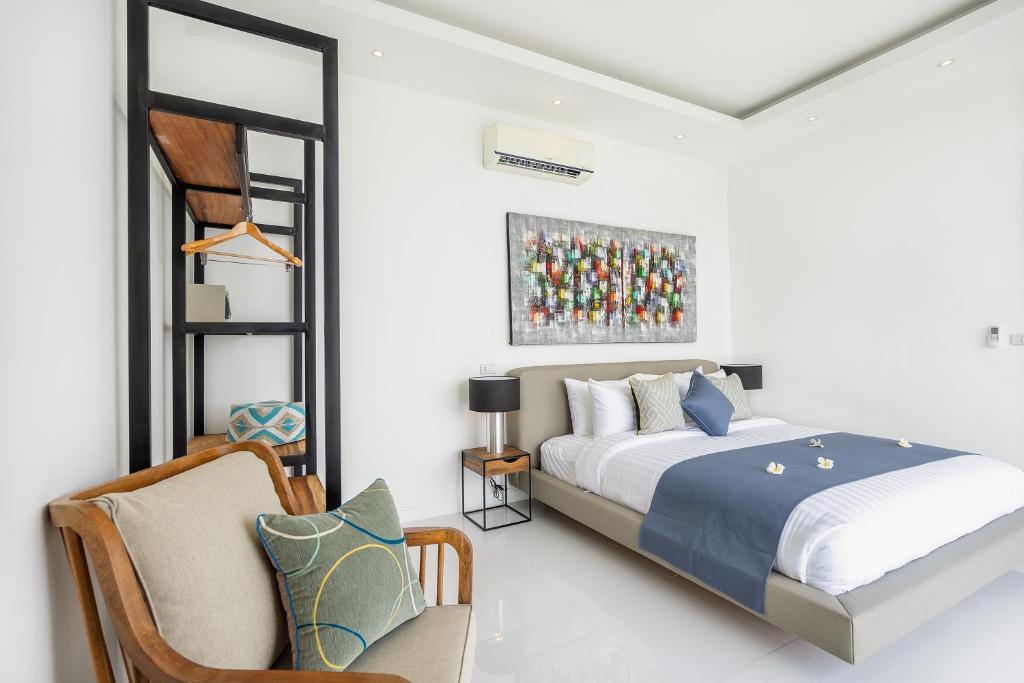 a bedroom with a king sized bed and a chair at Villa Claire - Seaview Private Villa in Bophut 