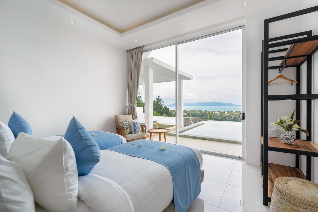 Un dormitorio con una cama grande y una ventana grande. en Villa Claire - Seaview Private Villa, en Bophut 