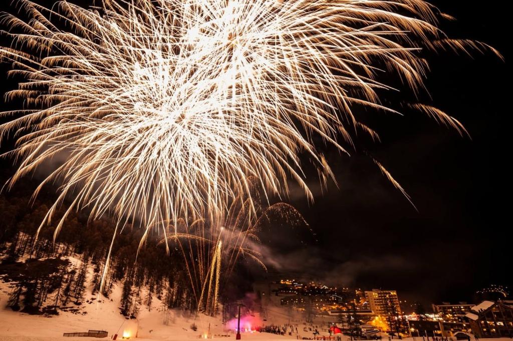 un espectáculo de fuegos artificiales en el cielo sobre una ciudad en Boost Your Immo Vars Les Gentiannes 19 en Vars
