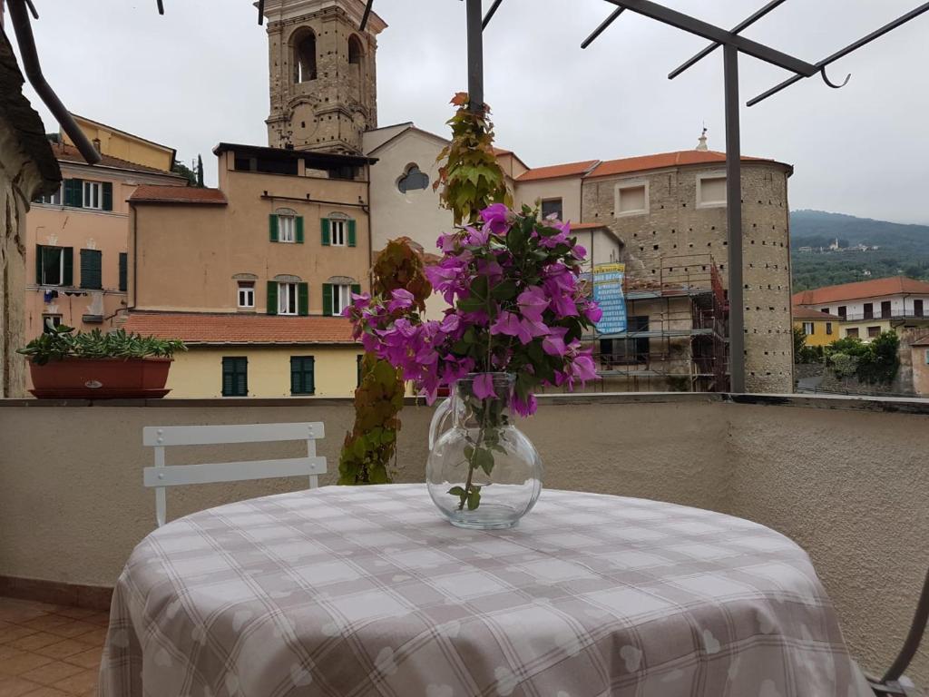 un vaso pieno di fiori viola seduto su un tavolo di Appartamento Stefano a Dolcedo