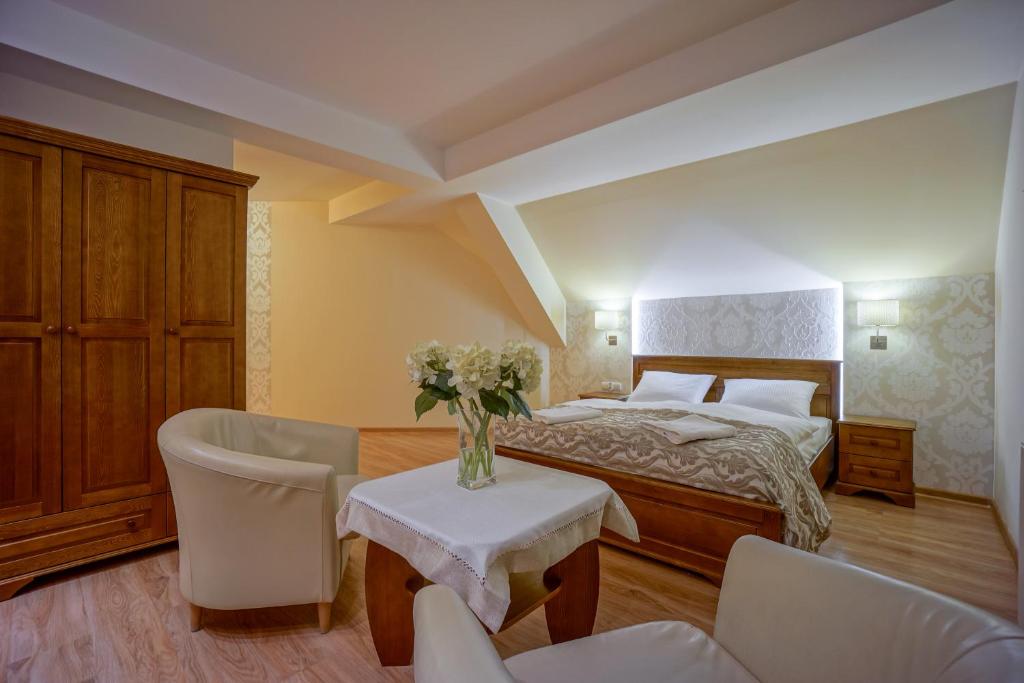 1 dormitorio con 1 cama, mesa y sillas en Jawor Pokoje i Apartamenty, en Zakopane