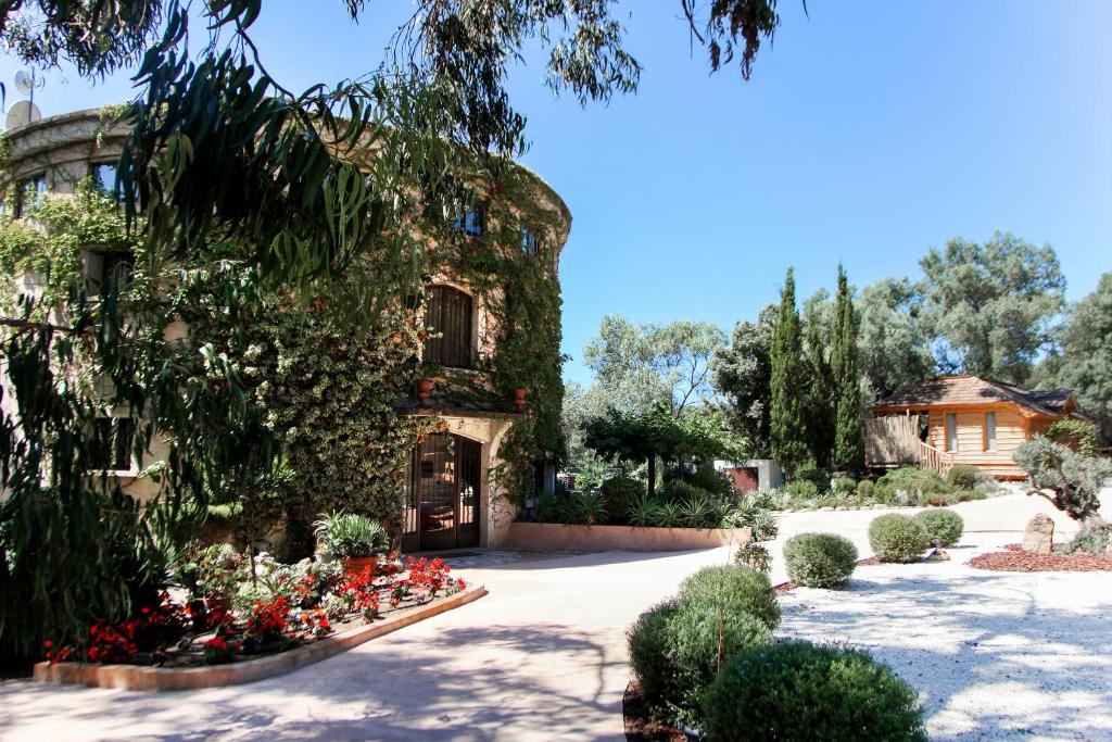 Un edificio con un mazzo di fiori in un cortile di L'Hostellerie du Moulin des Oliviers a Olmeto