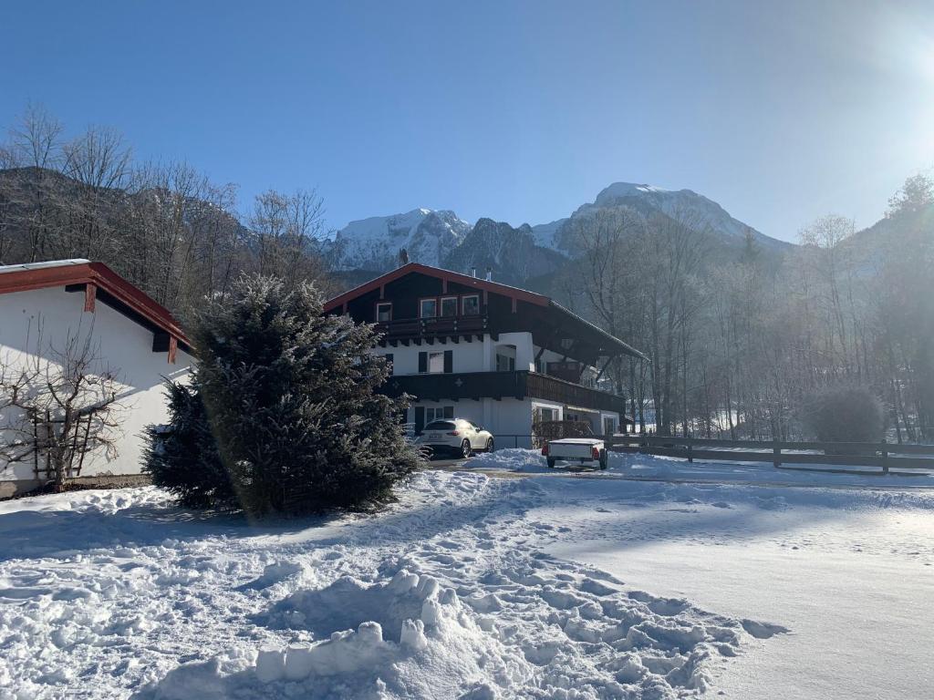 a snow covered building with cars parked in front of it at Im Schneewinkl in Schönau am Königssee