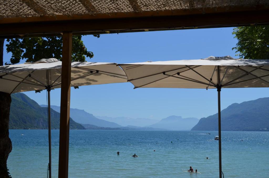 um grupo de pessoas nadando em um lago com guarda-sóis em Les Terrasses de Tresserve em Aix-les-Bains