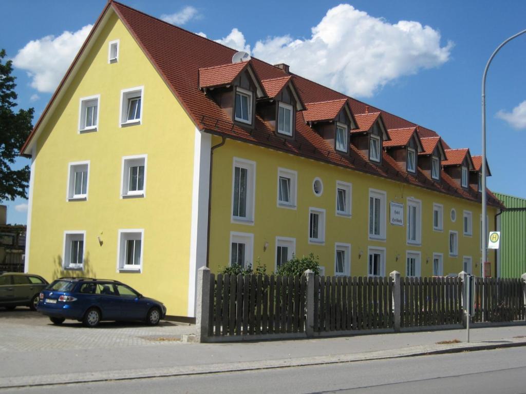 un grand bâtiment jaune avec un toit rouge dans l'établissement Komfort Apartmenthaus Haslbach FGZ, à Ratisbonne