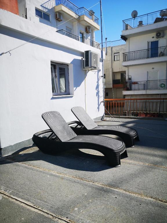 two chairs sitting on the side of a building at Explore Greece from Cozy City Centre Apartment in Chalkida