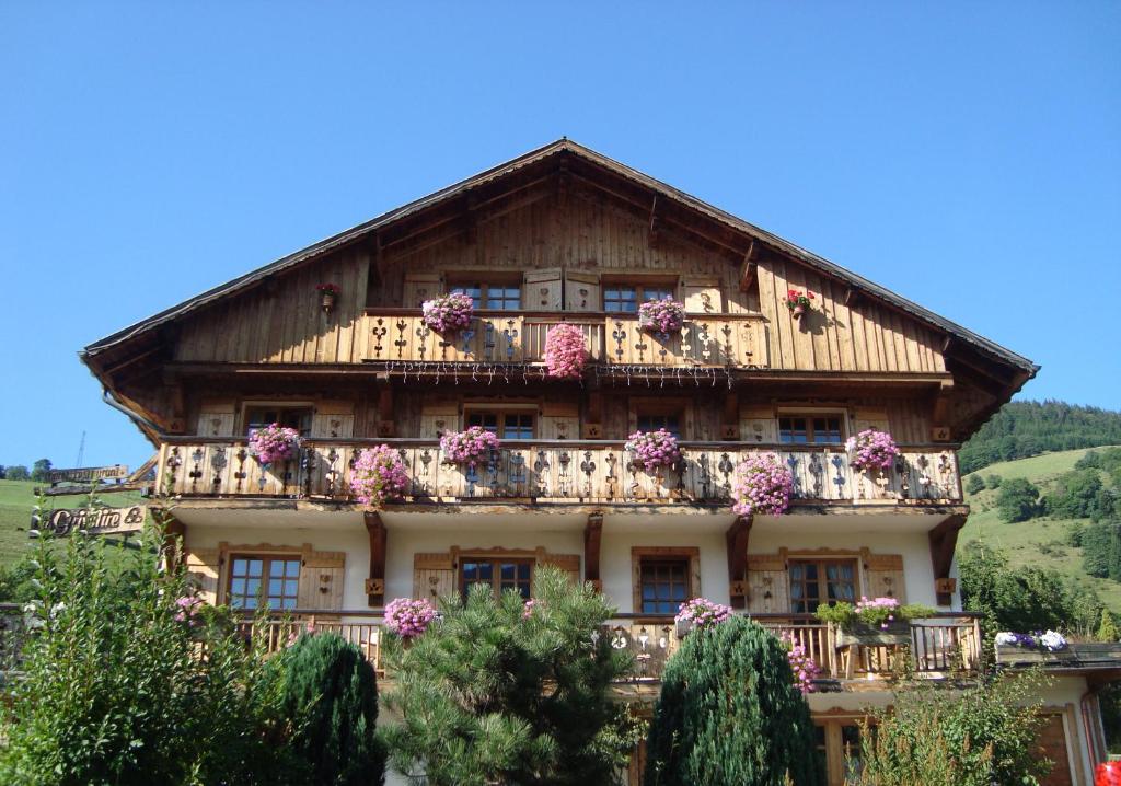 a large house with flowers on the balcony at Les Chalets de La Griyotire in Praz-sur-Arly