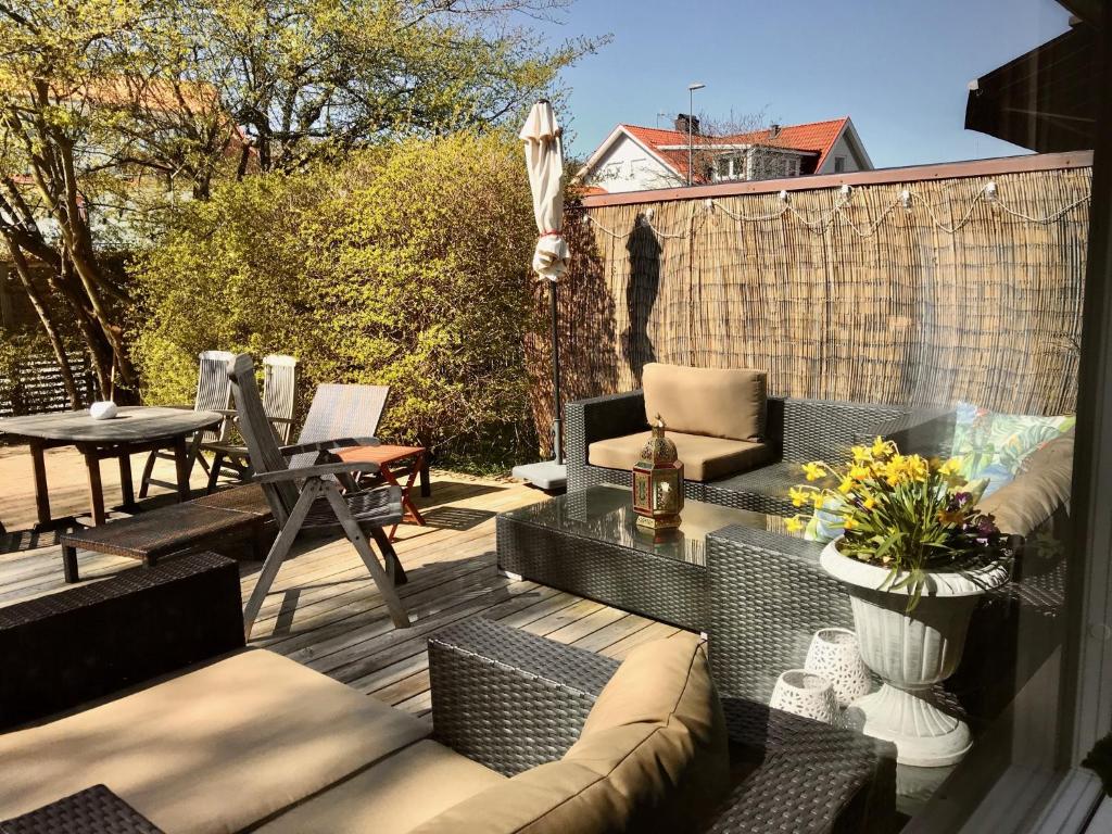 eine Terrasse mit einem Sofa und Stühlen auf einer Terrasse in der Unterkunft Holiday Home Liden in Båstad