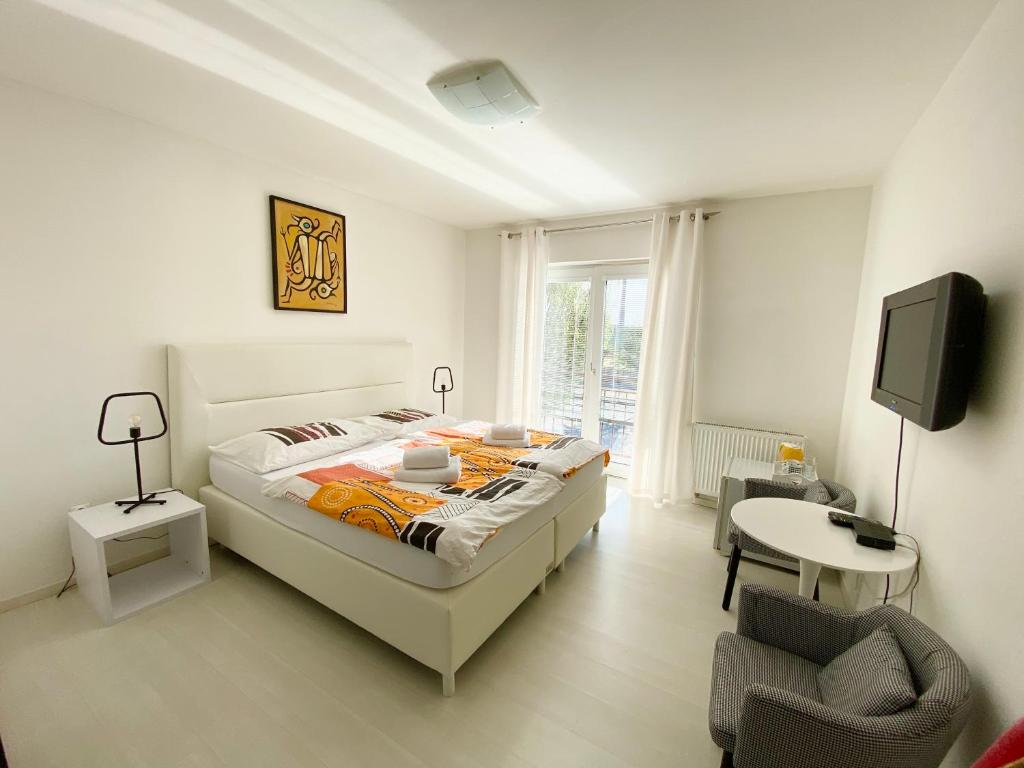 1 dormitorio con 1 cama, TV y silla en Penzión Oáza en Trnava