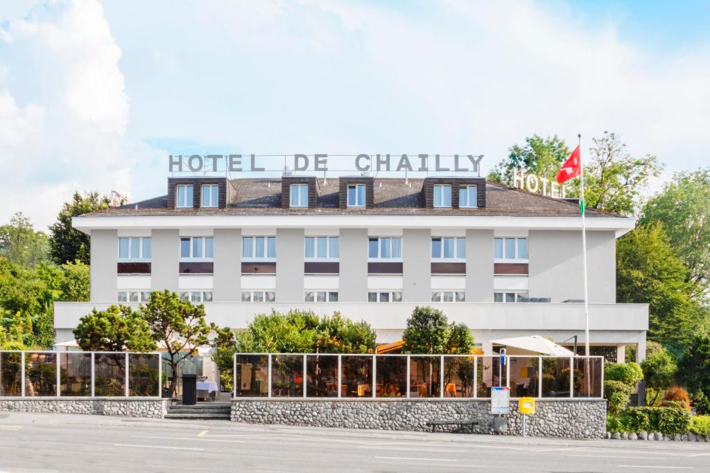 un bâtiment d'hôtel avec un drapeau en haut dans l'établissement Hôtel de Chailly, à Montreux