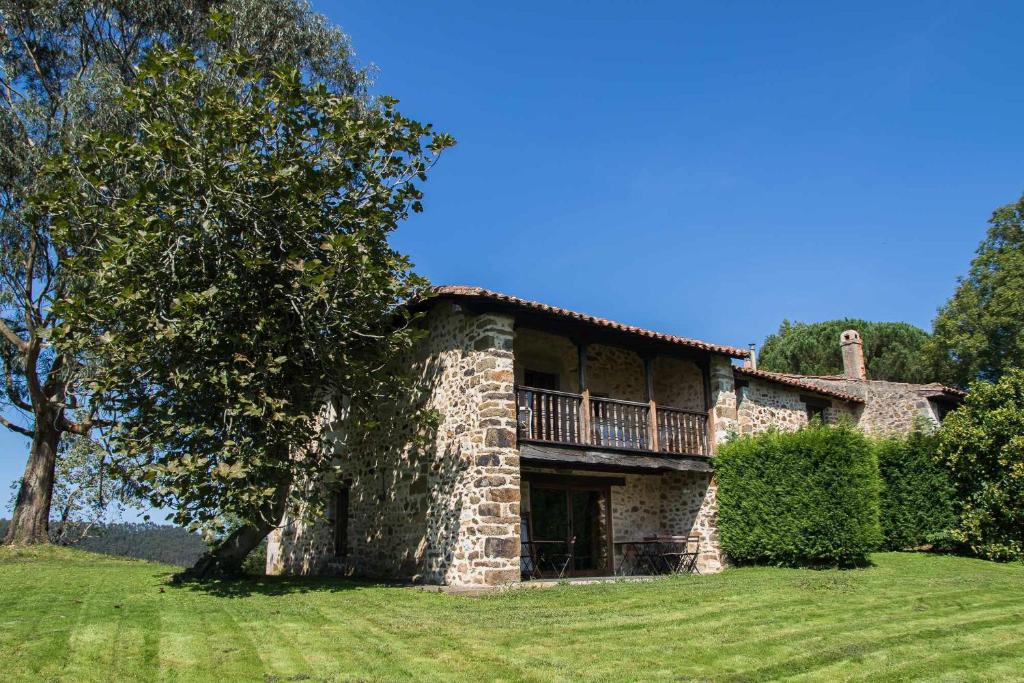 Casa de piedra grande con balcón en la parte superior. en Casa de Aldea Casa de Rubio, en Linares