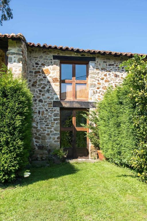 an old stone house with a wooden door and a yard at Casa de Aldea Casina de Rubio in Linares