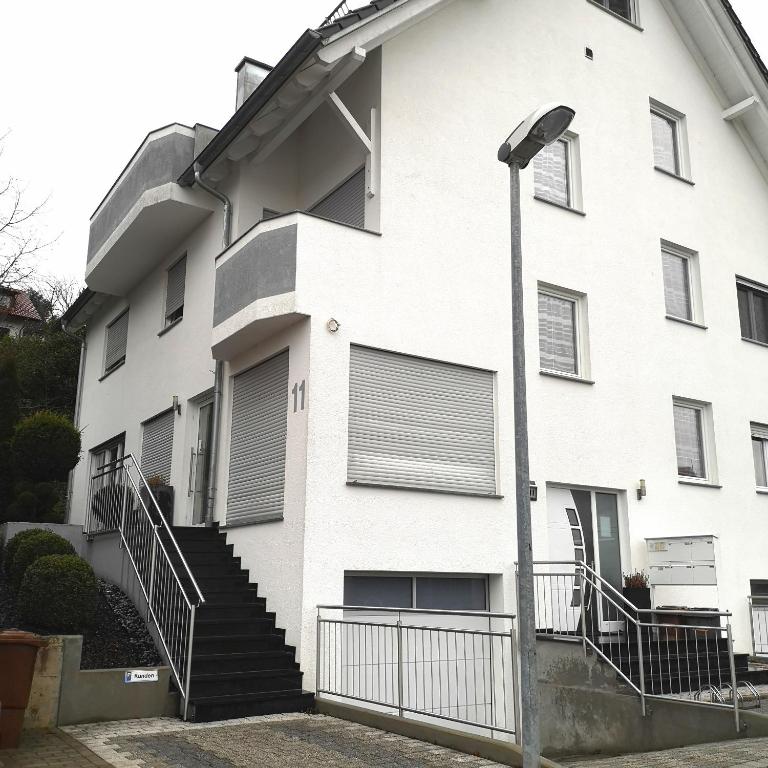 a white building with stairs and a street light at Ferienwohnung Noll in Friedrichshafen