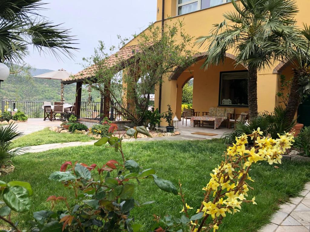 ein Haus mit einem Garten mit Blumen im Hof in der Unterkunft L'Acacia B&B in Pietra Ligure