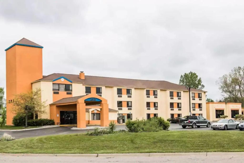 een gebouw met auto's geparkeerd op een parkeerplaats bij Days Inn by Wyndham Flint/Bishop International Airport in Flint