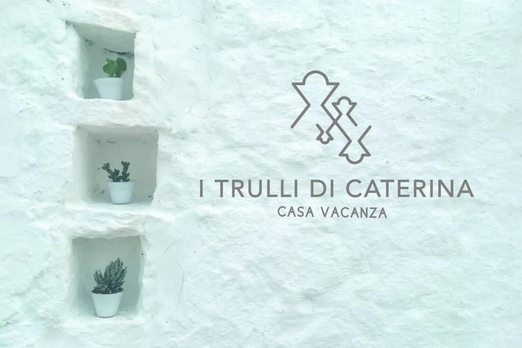 eine Gruppe von Topfpflanzen an einer weißen Wand in der Unterkunft i trulli di Caterina - casa vacanza privata in Martina Franca