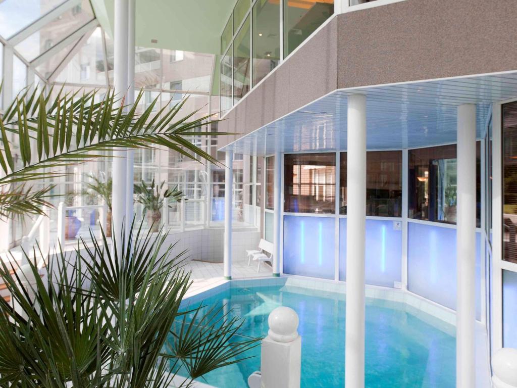 een groot gebouw met een zwembad voor een gebouw bij Hotel Mercure Grenoble Centre Président in Grenoble