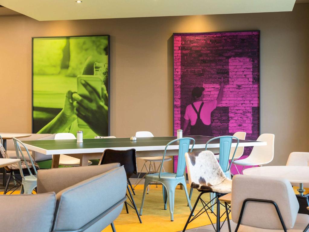 蘇黎世的住宿－蘇黎世展覽中心機場宜必思酒店，一间设有桌椅的房间和墙上的绘画