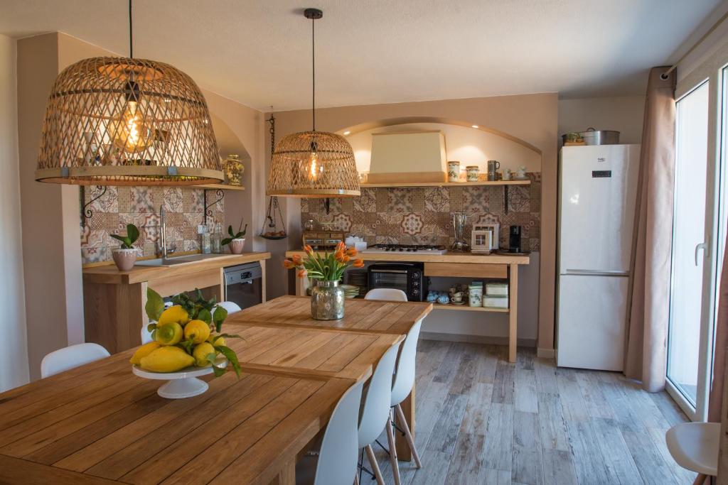 una cocina con una mesa de madera y un bol de fruta. en Sa tanca 'e Pedduzza en Orosei