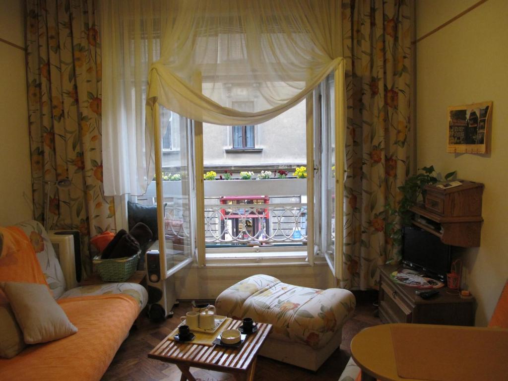 a living room with a couch and a large window at Studio Ravlić in Zagreb