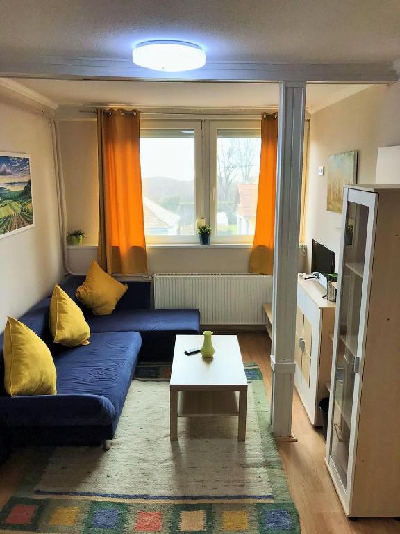salon z niebieską kanapą i stołem w obiekcie Kishableány Apartmanház w mieście Badacsonytomaj