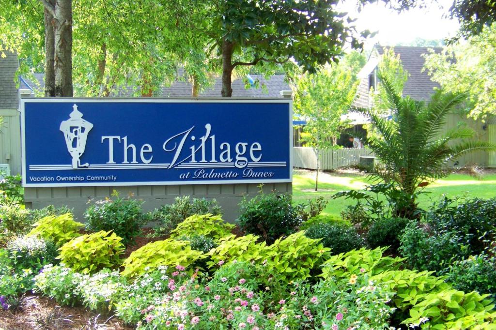 a sign for the village of amphibian village with plants at The Village Palmetto Dunes in Hilton Head Island