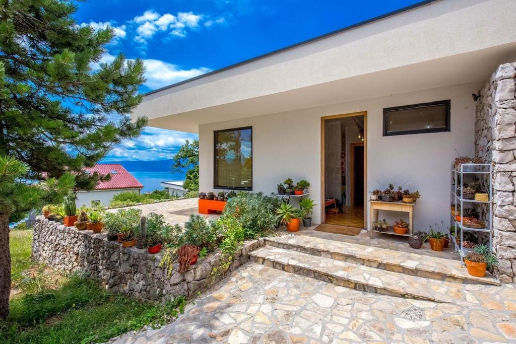 a house with a stone pathway leading to the front door at Villa Orange, small house in a pine forest in Kostrena