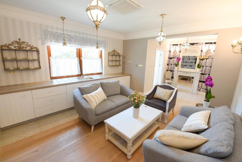 Bright living room with comfortable sofas, decorative lamps, and floral accents.