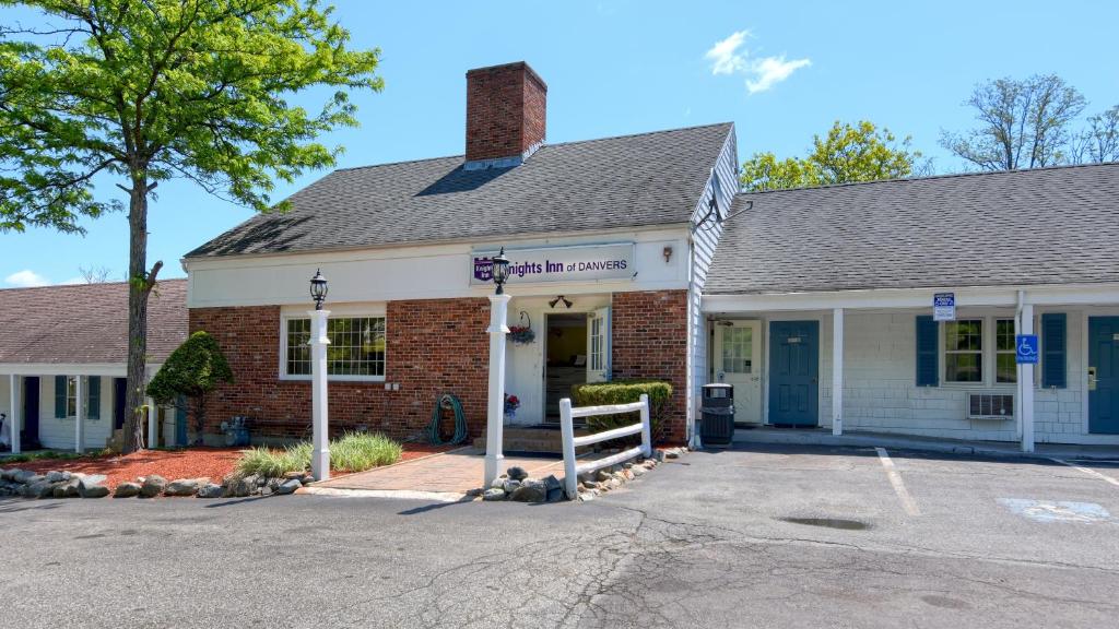 une maison en briques avec un panneau devant elle dans l'établissement Knight's Inn Boston/Danvers, à Danvers