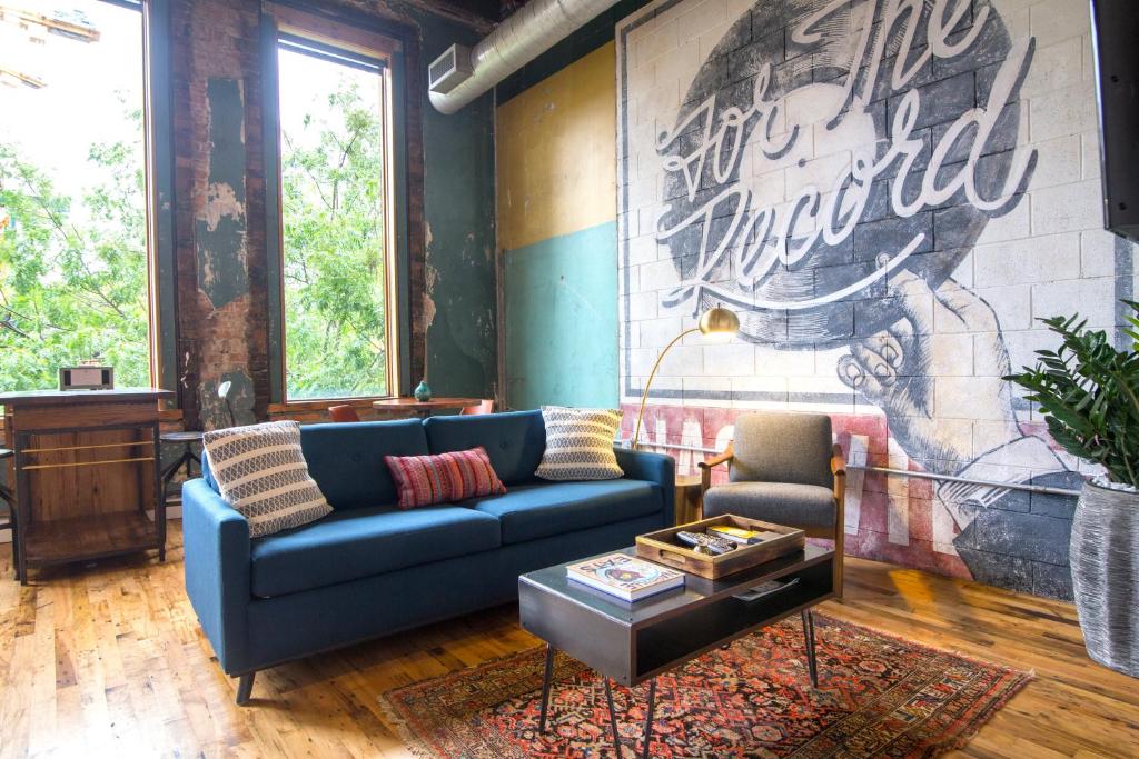 a living room with a blue couch and a mural at 506 Lofts in Nashville